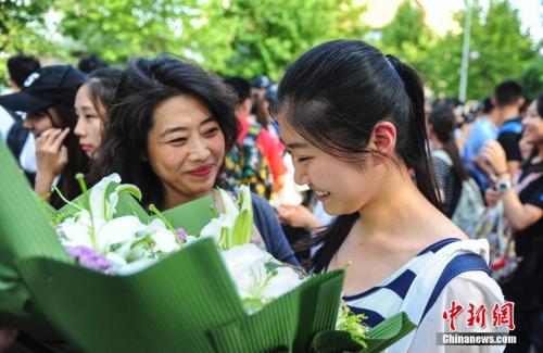 資料圖：山東濟南眾多考生手捧鮮花在家長的簇擁下歡快告別高考。中新社記者 張勇 攝