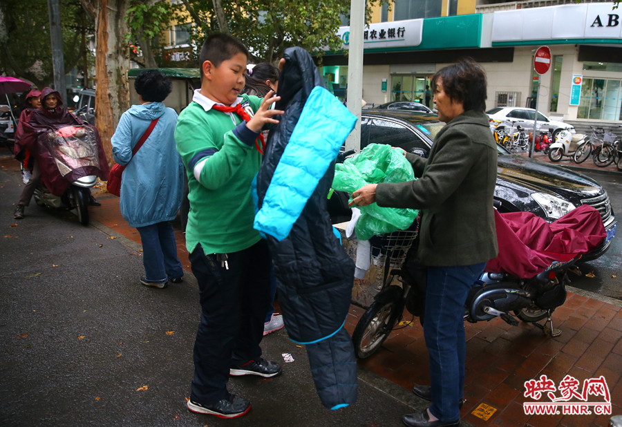 學校門口，家長給孩子帶來了御寒的厚衣服。