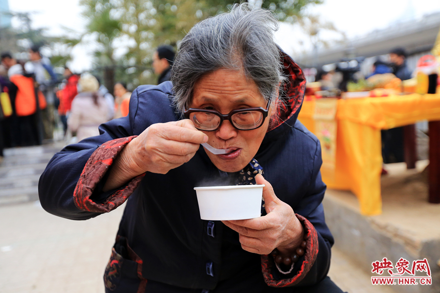 紫荊山施粥點老奶奶領到熱騰騰的臘八粥后馬上品嘗起來