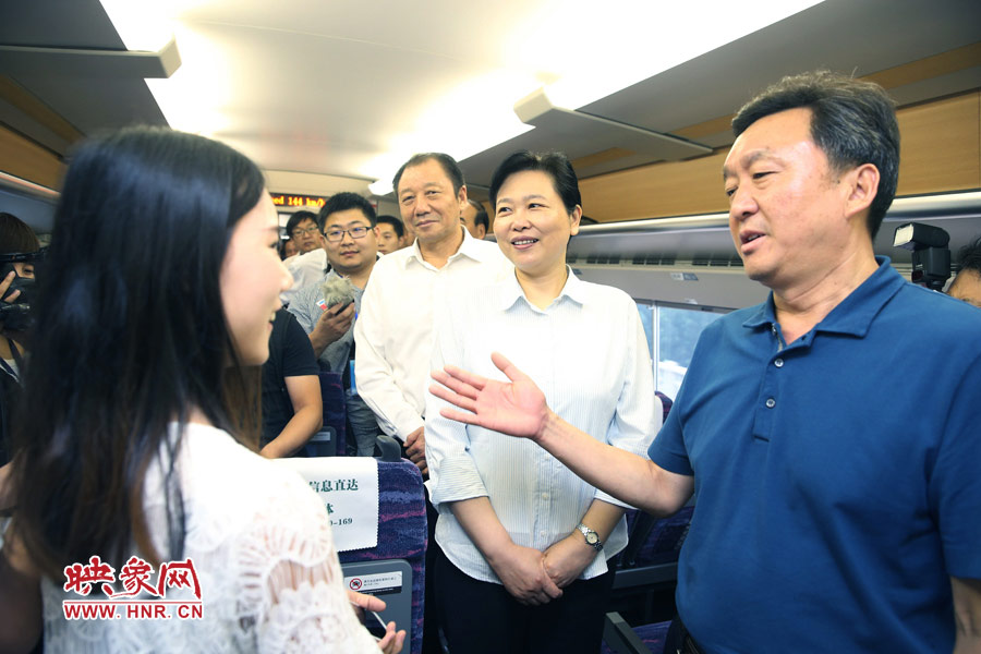 6月26日,首發的鄭焦動車上,副省長王艷玲(右二)和乘客交流