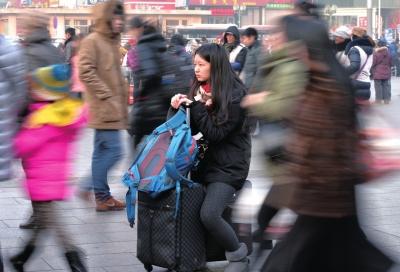 春運(yùn)首日，北京站客流量明顯增多，一名女孩在人流中等待進(jìn)站。