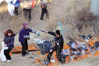 1月4日，連霍高速蘭州市榆中縣和平鎮段，一名警察舉著槍驅散哄搶橘子的村民。圖/CFP