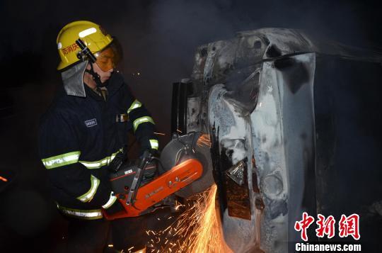 圖為消防人員破拆轎車，尋找4萬元現金。嚴光濤 攝