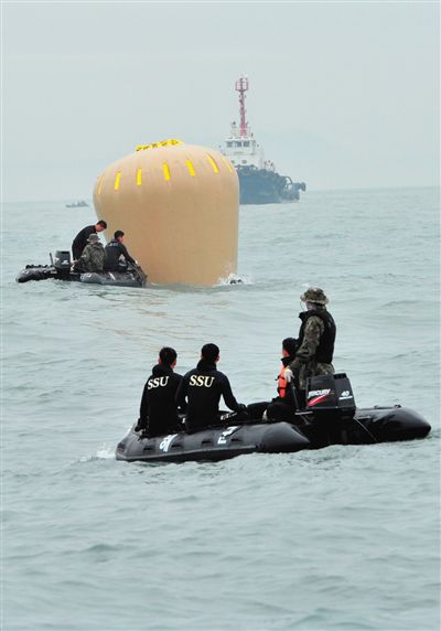 18日，搜救人員準備將氣囊捆綁到沉沒客輪上。