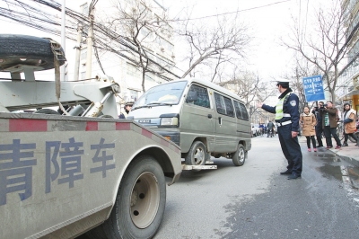 聯合執法人員將市民舉報的違法占道經營車輛拖走暫扣