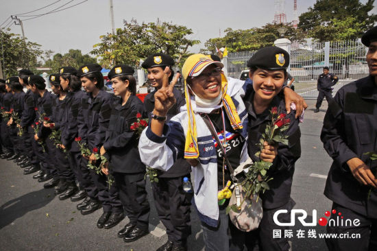 2013年12月03日,曼谷總理府與曼谷警署允許反政府示威民眾進入,雙方進入暫時“停戰”狀態迎接泰王生日。曼谷警察總署,女警們手持鮮花送給反政府示威民眾。圖片來源:Manish Swarup/東方IC