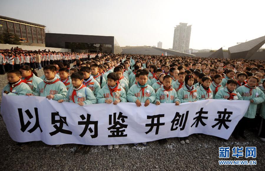 ，南京市小學生代表手持“以史為鑒 開創未來”的橫幅在南京大屠殺遇難同胞紀念館集會廣場參加悼念儀式。　