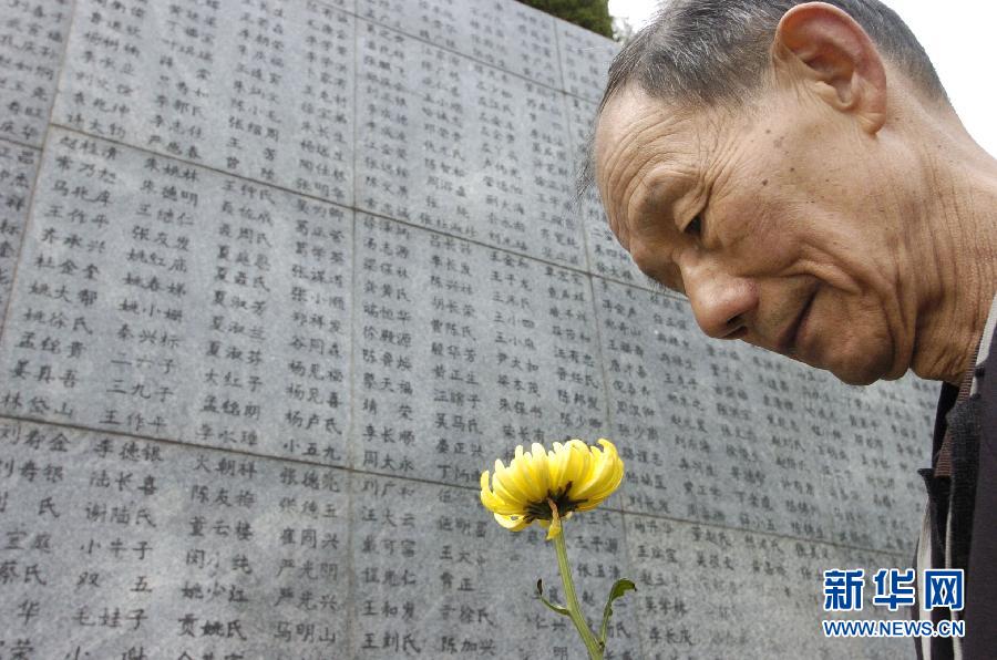 2006年4月5日，74歲的南京大屠殺幸存者佘子清手捧鮮花，祭奠被日軍殺害的母親。