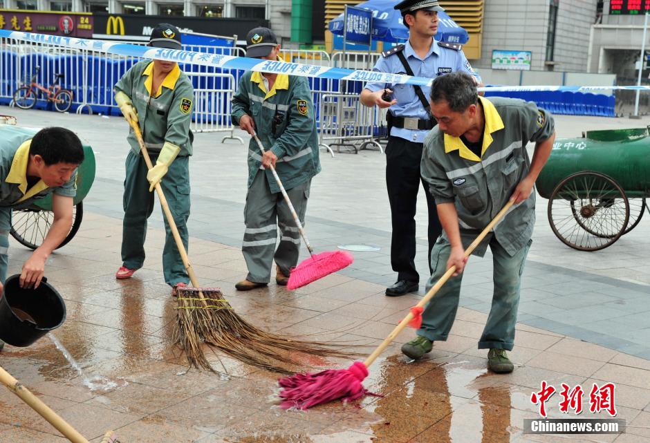 圖為環(huán)衛(wèi)工人在清理案發(fā)地點的血跡。