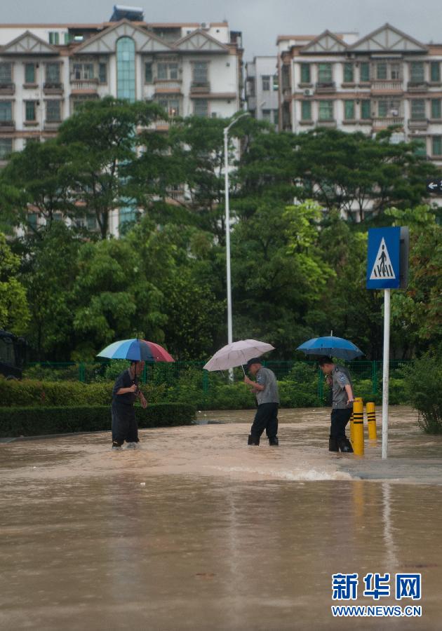 5月11日，人們在深圳西麗涉水行走。