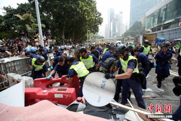 10月14日，警方清除金鐘道障礙物。大批警員在金鐘道現(xiàn)場(chǎng)清拆障礙物。部分警員戴上頭盔將障礙物移走。