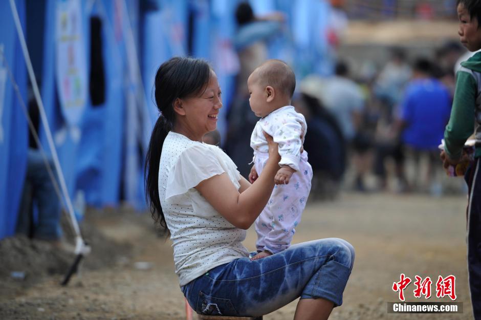 8月6日，一名年輕的母親在和孩子玩樂。