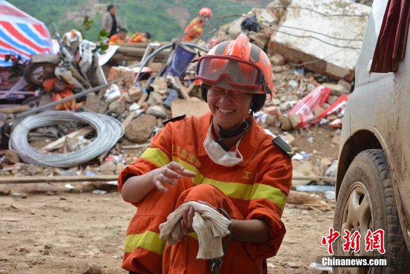 2014年8月5日，女兵在云南魯?shù)辇堫^山鎮(zhèn)廢墟中搜救被困者。