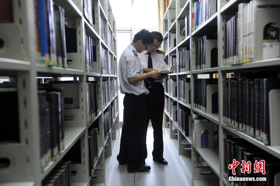 5月8日，武漢輕工大學保安吳濤與江力在圖書館交流學習。中新社發 張暢 攝