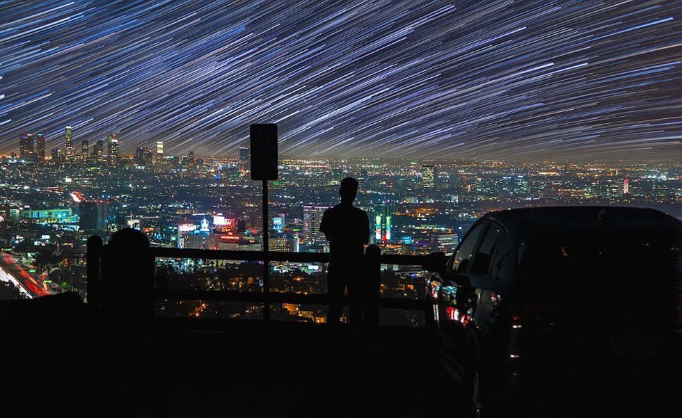 照片中，一名男子看著流星和隕星劃過天空。（網頁截圖）