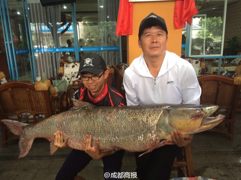 這對父子抱著他們釣起的大魚