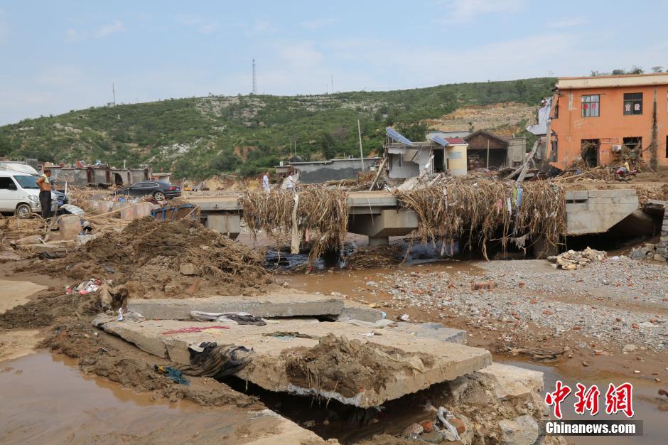 圖為洪水過后，坍塌的橋梁上遺落大量雜草。