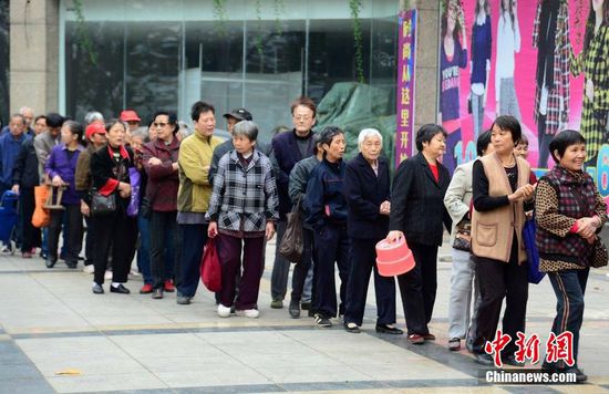 圖為10月28日，在江西九江市一家羊絨皮草服裝服飾博覽會現場，老人們正在頂著寒風排隊等待領取10元代金劵。