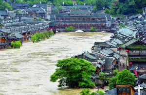 7月16日,沱江兩邊的商鋪和遠(yuǎn)處的虹橋仍淹沒(méi)在洪水中。 新華社發(fā)